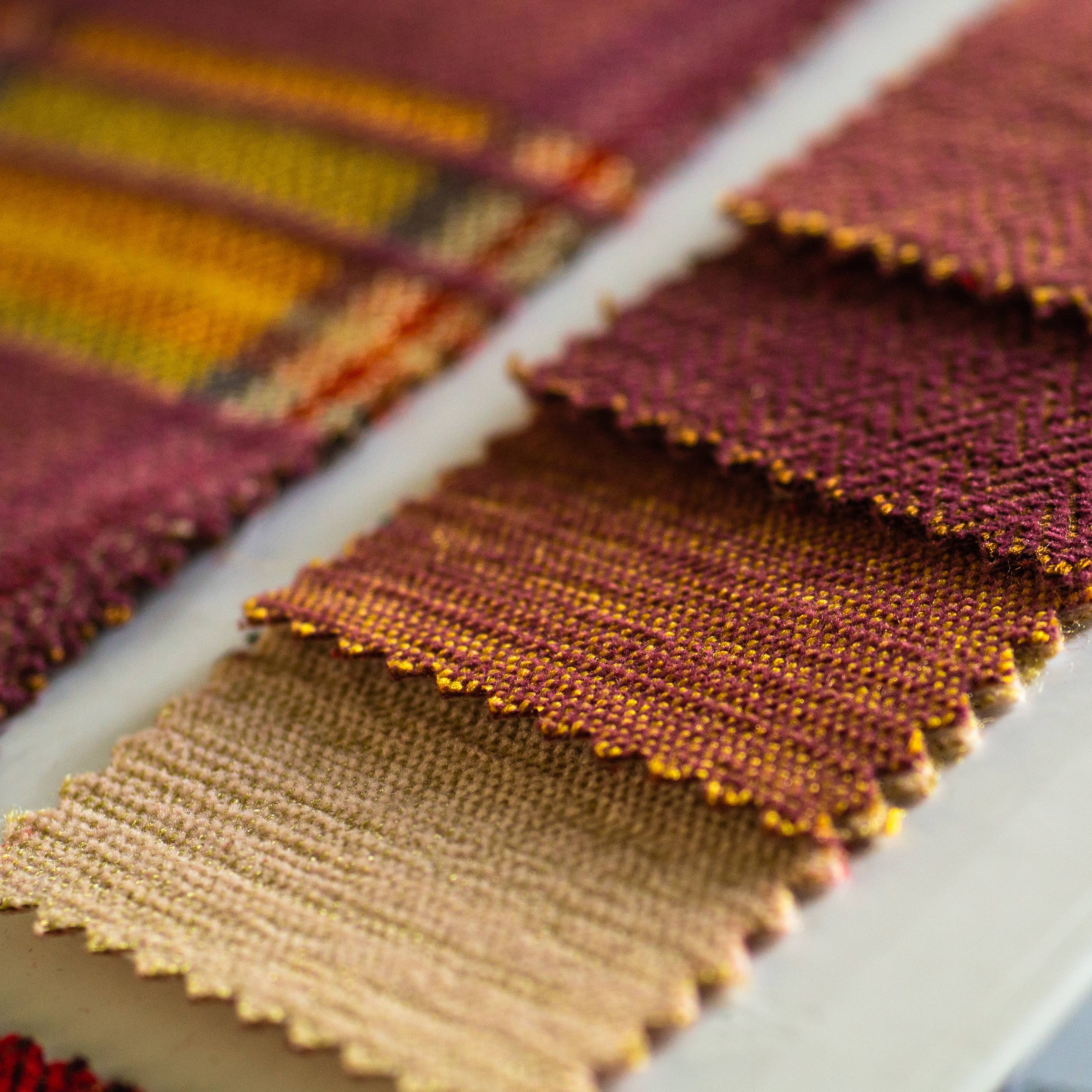 Persona eligiendo tejidos de calidad en una tienda textil de Ciudad Real, rodeada de estanterías con ropa de hogar y textiles variados